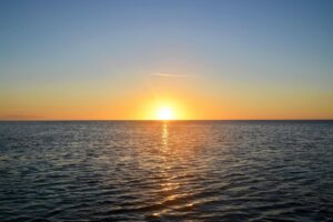 This image has an empty alt attribute; its file name is Sun-on-water-300x200.jpg